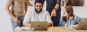 Group of Happy Employees Working Together on Laptop