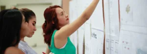 Woman Pointing at Board In Continuous Learning Exercise