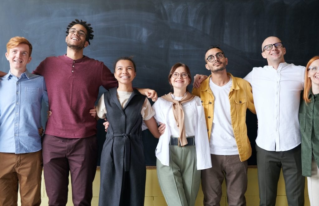 Employees In Front of Blackboard Taking Team Picture