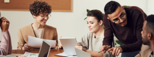 Group of Employees Working on Laptops Around Board Table