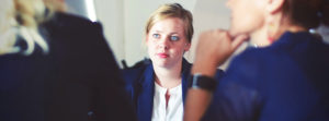 Woman Sitting Across From Two Colleagues in Meeting