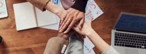 Six Hands Stacked Over Each Other in a Collaborative Team Gesture