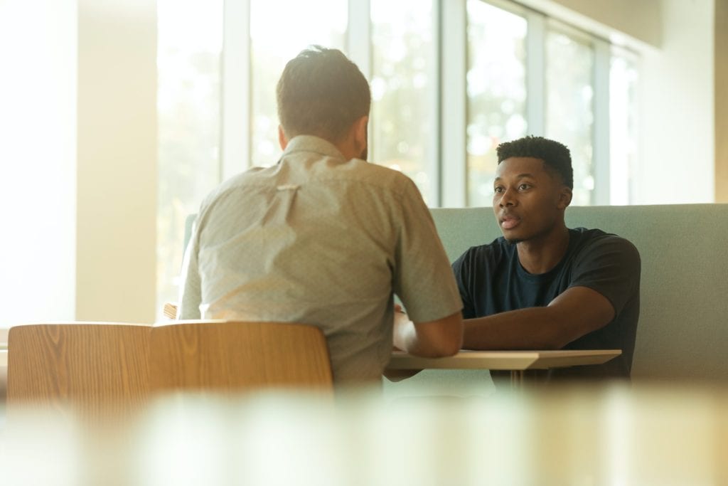 Two Men Sitting Across Each Other in Employee Coaching Session