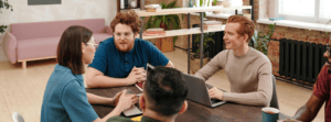 Employees Having a Meeting Around Board Table in Office